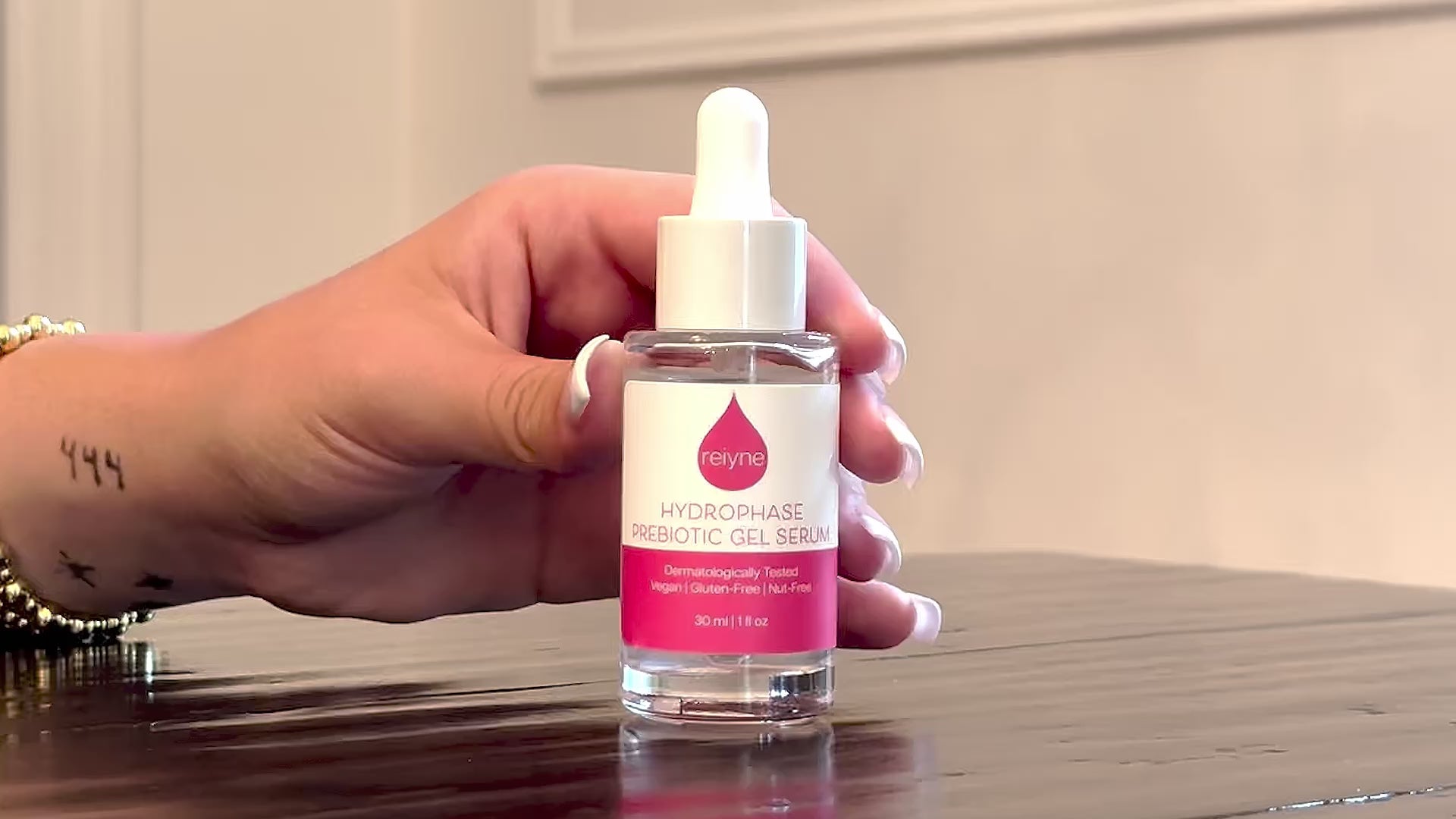 Reiyne HydroPhase Prebiotic Gel Serum in a clear bottle with white dropper and a pink and white label
