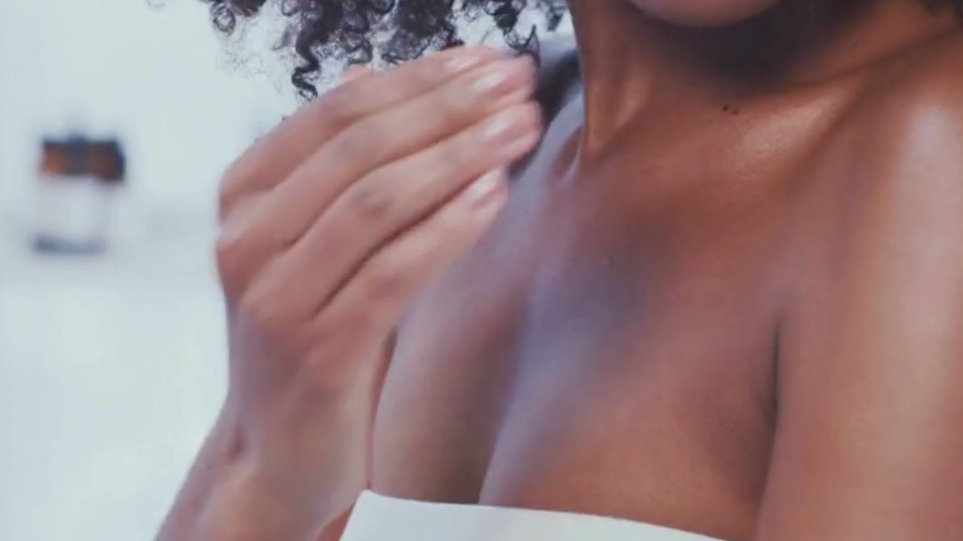 Reiyne bare body cream rubbed into shoulders of an African American woman